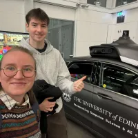 PhD researcher and student shadow at an automated car exhibition in Informatics