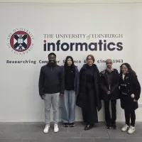 PhD researchers and their student shadows in front of the School of Informatics sign