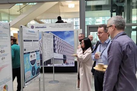 Event attendees looking through students' posters
