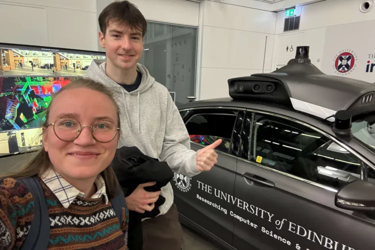PhD researcher and student shadow at an automated car exhibition in Informatics