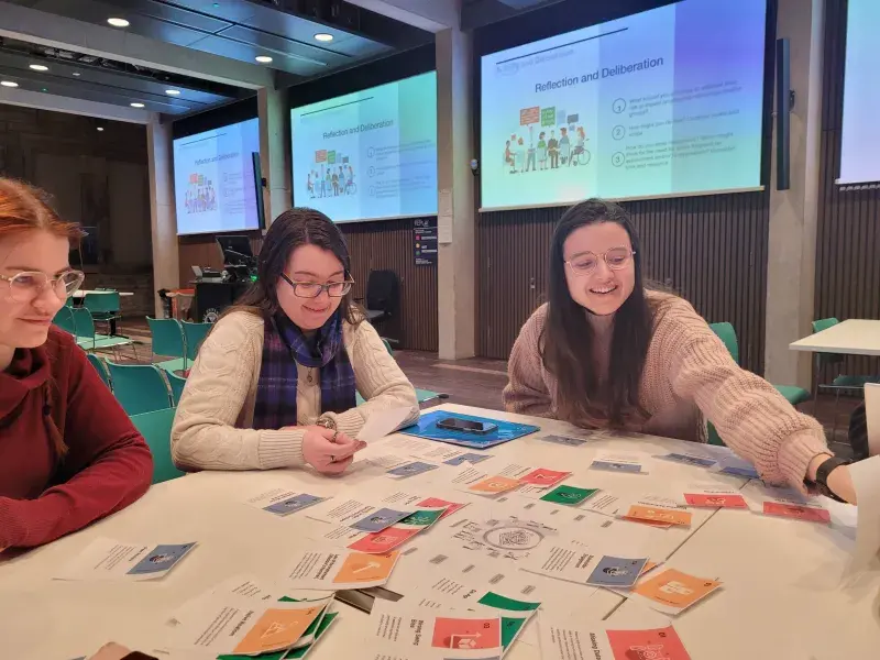 Our students in discussion around a table at a training session on Responsible Research and Innovation