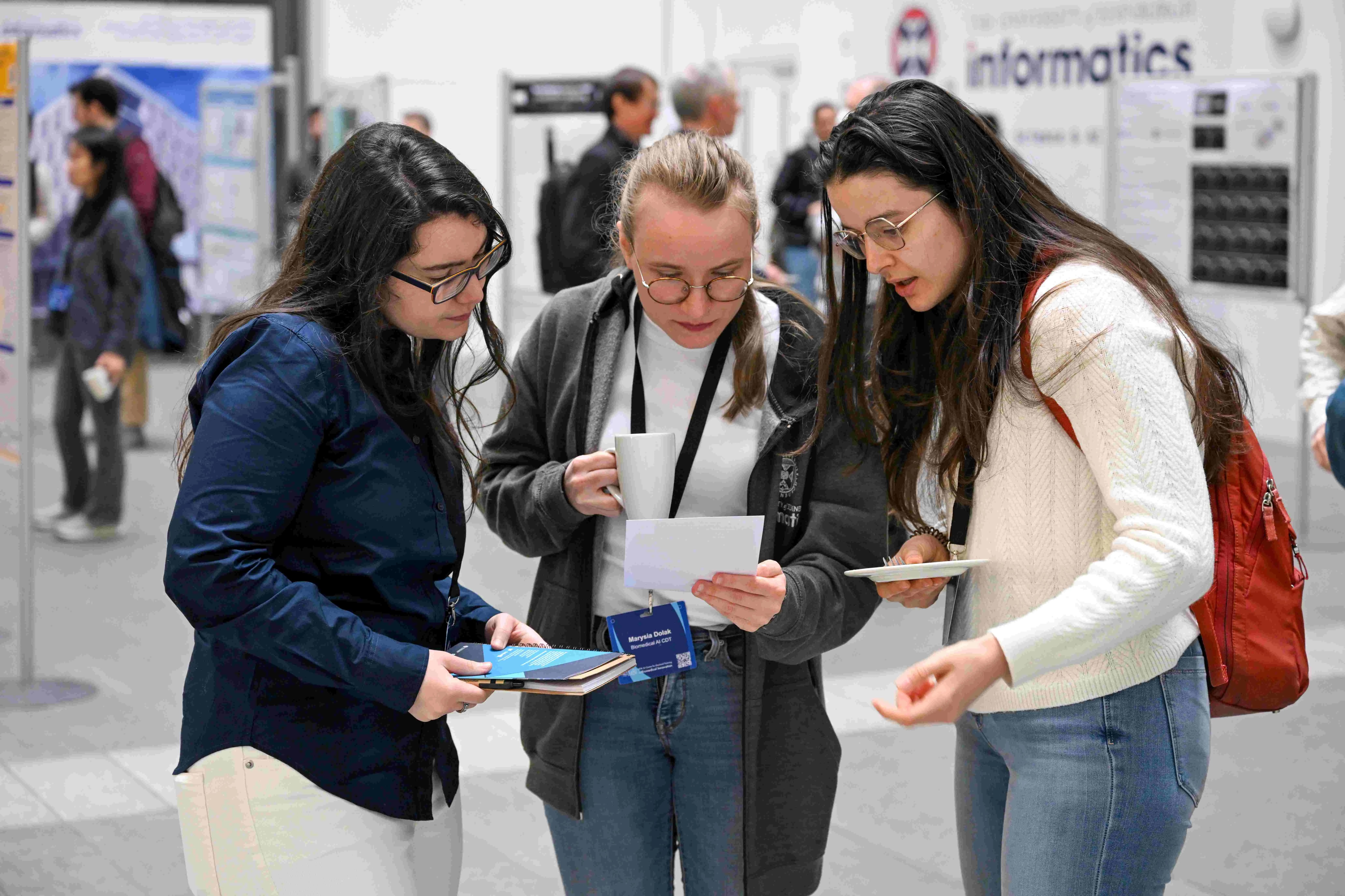 Three students in discussion at our annual AI4BI Forum