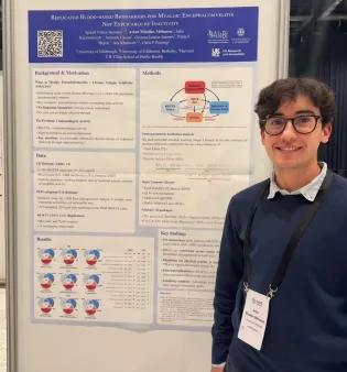 Artur standing in front of his poster at the conference